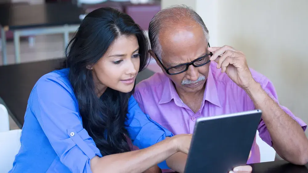 father and daughter looking at a tablet 