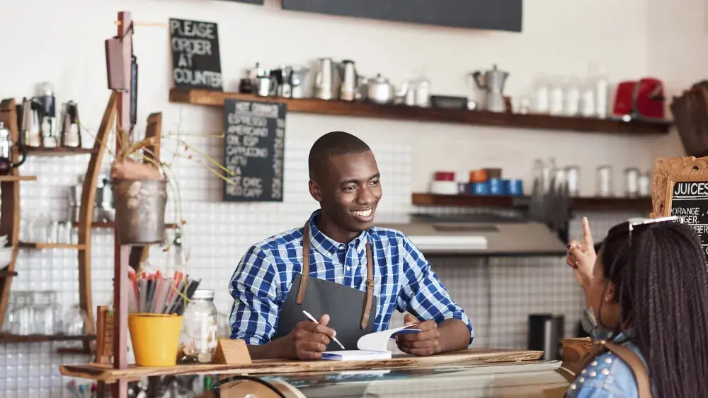 man taking orders in cafe