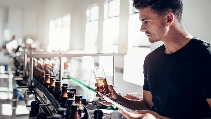 man testing beer in brewery