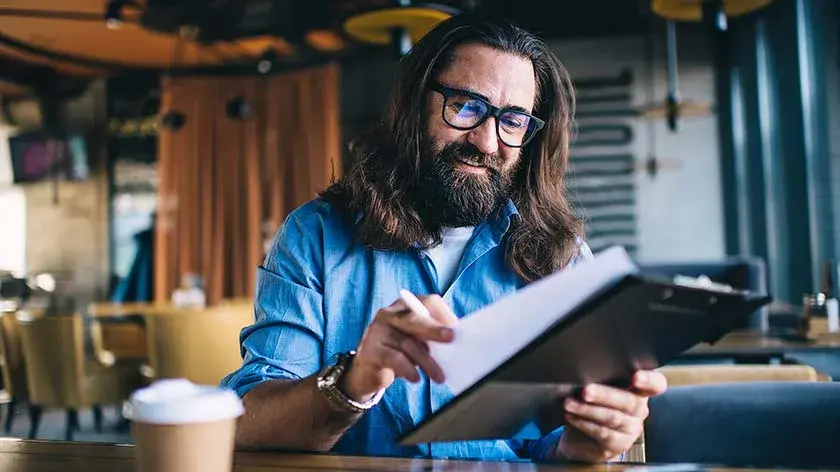 man-looking-over-paperwork-smiling