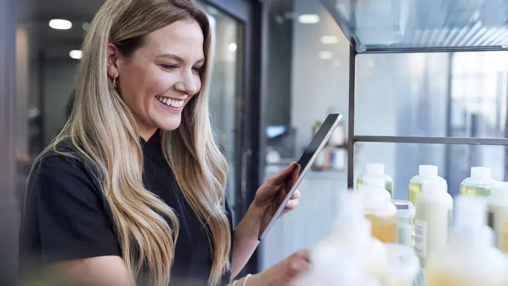 smiling woman taking inventory using a tablet