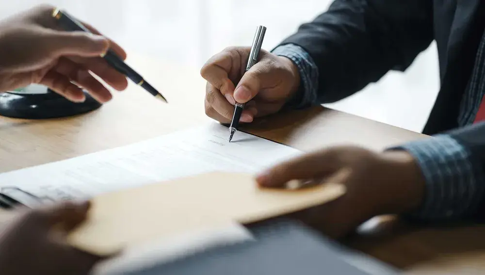 An attorney breaks down probate lawyer fees. The attorney is seated across a desk or table from a client. 