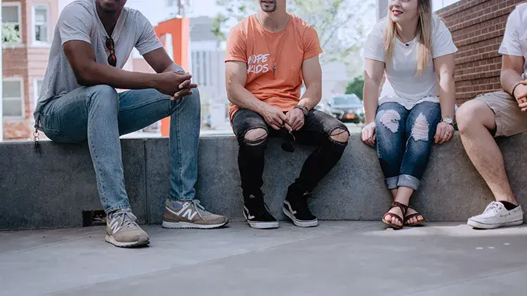 volunteers at nonprofit LLC sitting on concrete 