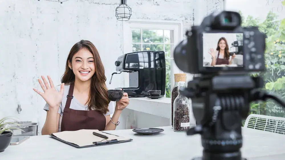 woman filming and drinking coffee