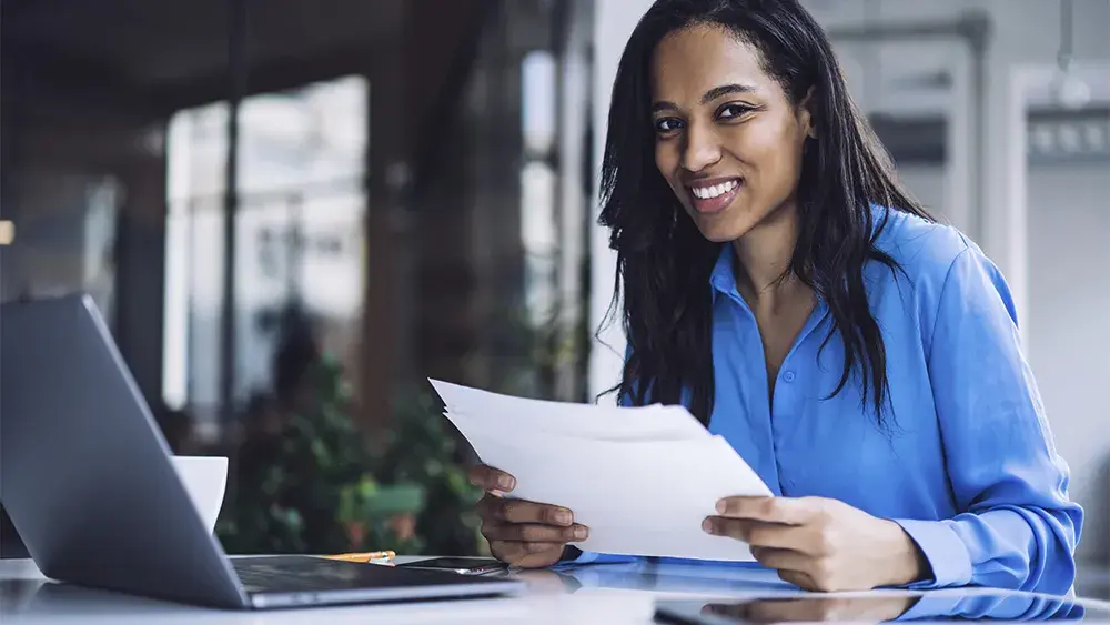 woman in blue shirt looking at paperwork