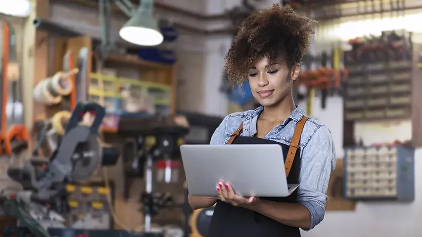 woman in overalls working on laptop