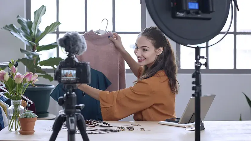 woman showing a shirt while she is live on social media 