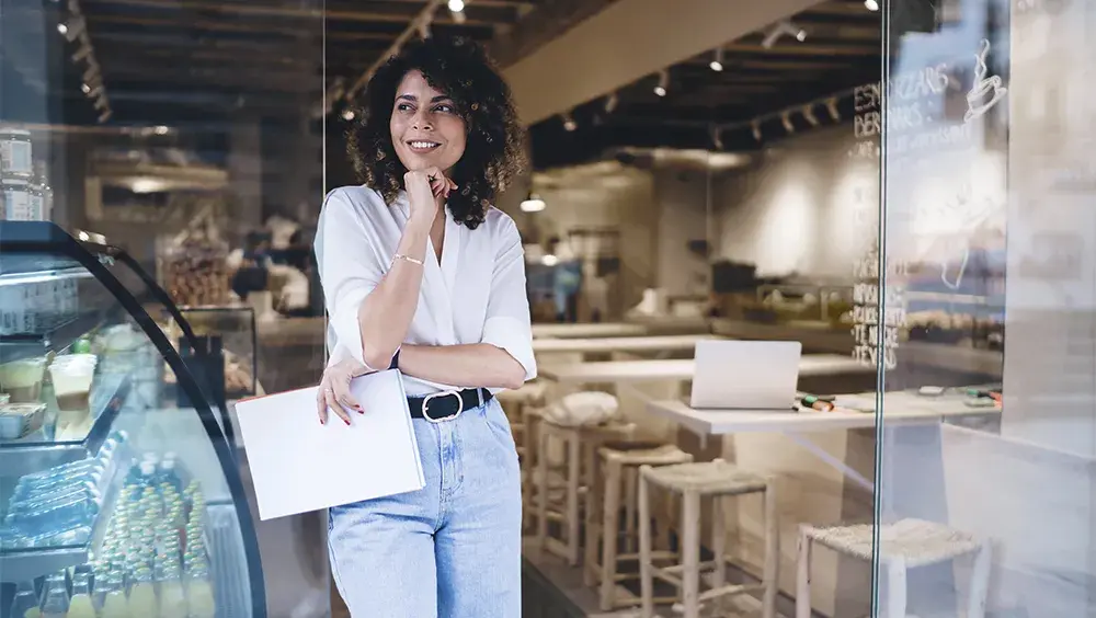 woman standing outside of her cafe