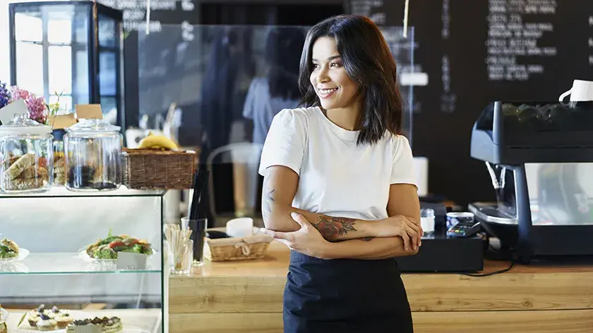 woman with tattoos in front of the counter in a coffee shop