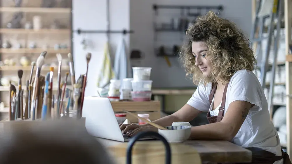 woman working on laptop in art studio