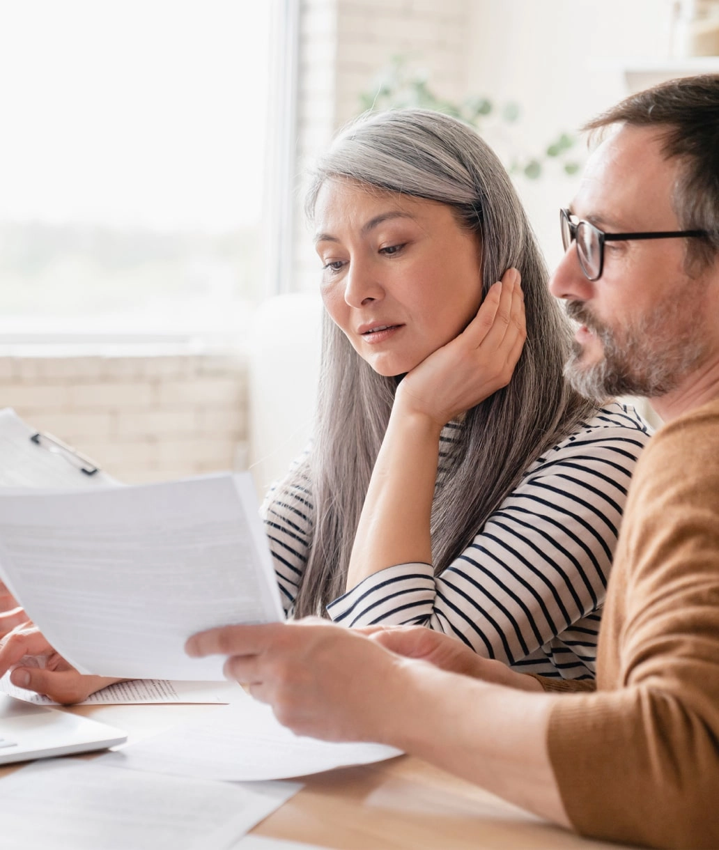 Woman in striped long sleeve discussing paper work with man