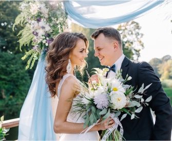 A female wedding planner reviewing proposal with bride at an outdoor wedding